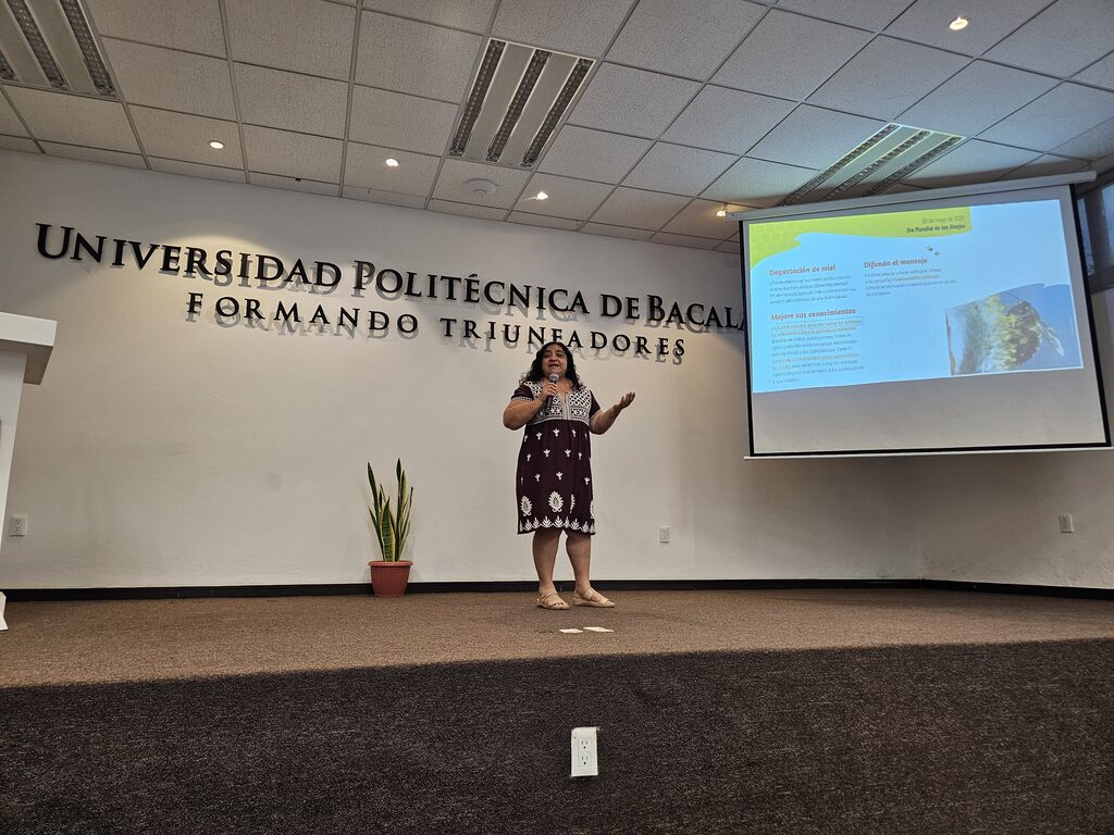 Integrante de Miel de Flores Mayas dando una presentación en una universidad