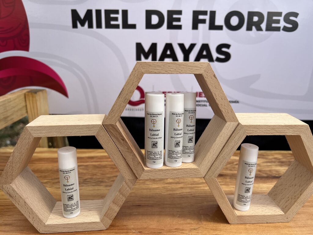 Bálsamos elaborados por Miel de Flores Mayas exhibidos en soportes de madera
