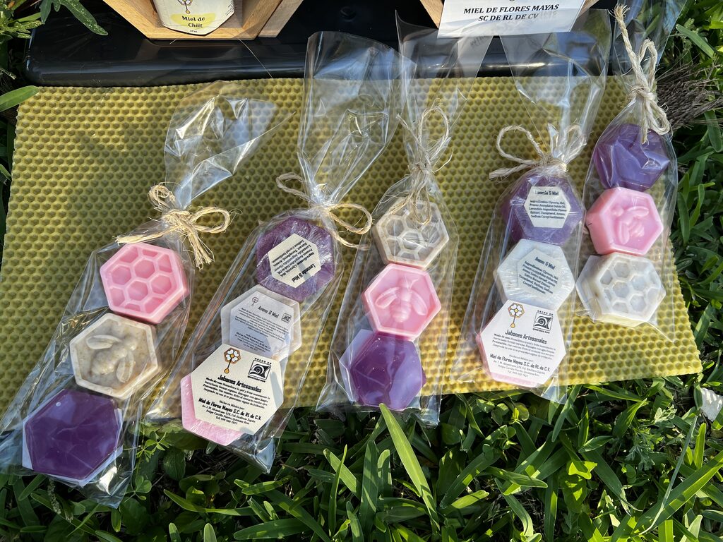 Jabones artesanales de colores empacados sobre una lámina de cera